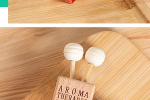Detail of wooden aromatherapy diffuser clip with Aroma Therapy text and white cotton spheres