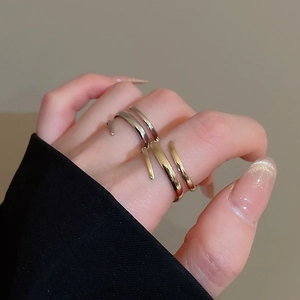 Detail of minimalist gold and silver open rings with elegant curved metal lines