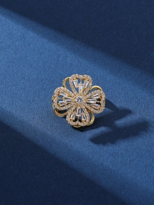 Detailansicht der drehbaren Kleeblatt-Brosche mit funkelndem Zirkon in Gold-Veredelung
