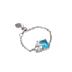 Silver chain ring featuring pear-shaped white zircon and blue rectangular gemstone charm