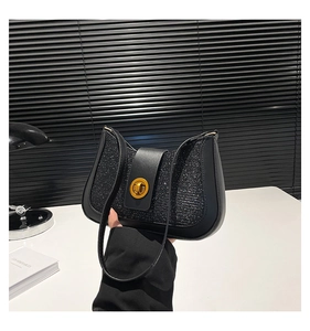 Close-up of black sequined underarm bag with gold twist lock and sleek leather strap