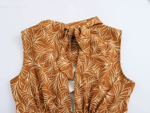 Close-up of brown sleeveless dress featuring coconut tree print and keyhole tie neckline
