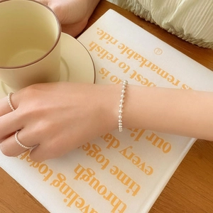 Minimalist S925 sterling silver 2mm bead bracelet and matching rings on a model