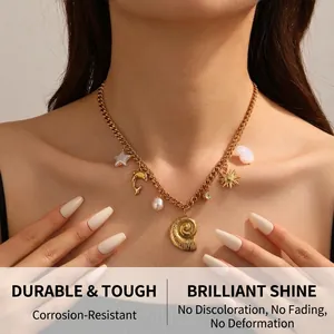 Detailed close-up of a gold conch, dolphin, and pearl pendant necklace on a model's collarbone