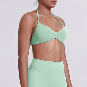 Detail of mint green seamless ribbed sports bra with halter neck and shirred bust design