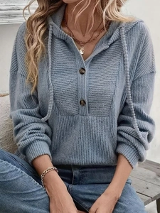 Detail of blue ribbed knit hoodie with decorative buttons and V-neckline texture