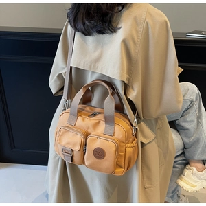 Rückansicht einer kamelfarbenen Nylontasche mit mehreren Taschen im lässigen Außeneinsatz