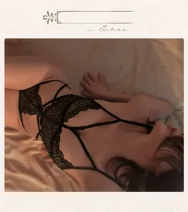 Detail of black lace bodysuit featuring cross straps and intricate hollow-out floral patterns