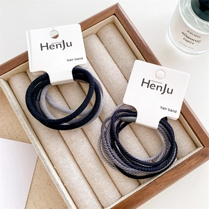 Close-up of high elasticity hair bands in navy and grey on a decorative wooden display