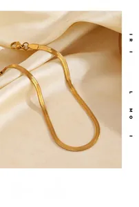 Close-up of sleek gold snake bone chain link texture on elegant silk fabric