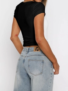 Rear view of minimalist black short sleeve tee paired with light blue straight jeans
