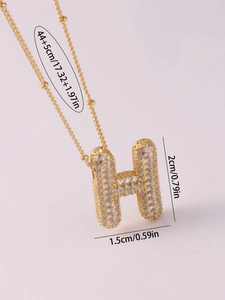 Detail of H bubble pendant with cubic zirconia on gold beaded chain and extender