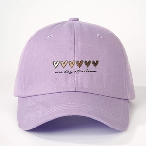 Detailed view of lavender cotton twill baseball cap with gradient heart and slogan