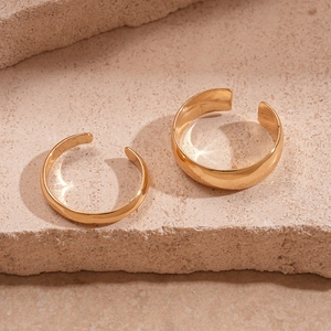 Macro view of two adjustable 18K gold-plated minimalist rings on a natural stone surface