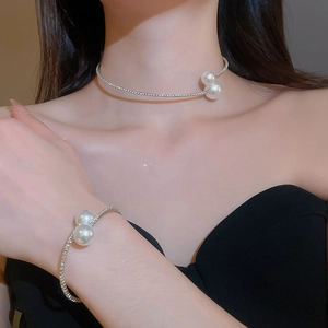 Close-up of pearl and rhinestone jewelry set on model with necklace and bracelet