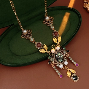 Gros plan d'un collier vintage avec strass colorés sur une boîte en velours vert