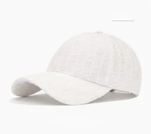 Detailed view of the white baseball cap featuring unique waffle texture and premium fabric