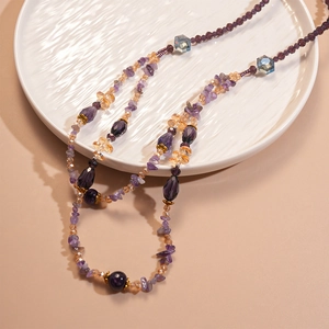 Close-up of bohemian layered beaded necklace with purple crystals and amber glass beads