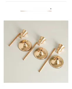 Detail view of the detachable parts of three gold metal candle holders for easy assembly