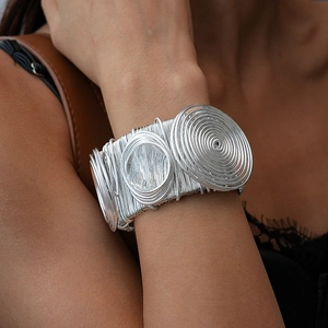 Gros plan du bracelet manchette argenté multicouche avec texture spirale unique
