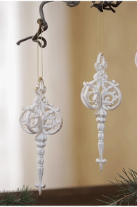 Close-up of vintage white and gold carved Christmas ornaments hanging on branches