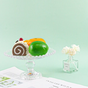 Realistic artificial chocolate cake and fruit slices set on a stylish glass tray decor