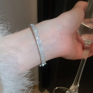Detail shot of silver bangle with double-row rectangular zircon worn by a model
