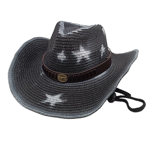 Detail of black straw cowboy hat with leather band, metal bull head and chin strap