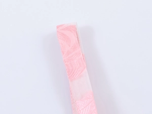 Détail rapproché du tissu jacquard rose avec une texture ondulée élégante sur la robe