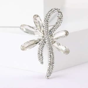 Macro shot of silver dragonfly brooch with sparkling rhinestones and crystal wings