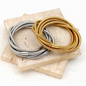 Layered gold and silver snake chain bracelets in stainless steel with cylindrical clasp