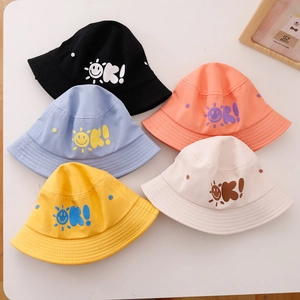 Vista piatta di cappelli a secchiello colorati per bambini con stampe sole e OK