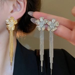 Detailed close-up of 18k gold plated flower earrings with elegant tassels and pearls