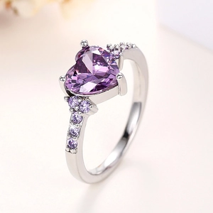 Macro detail of heart-shaped purple gemstone ring with polished silver band setting