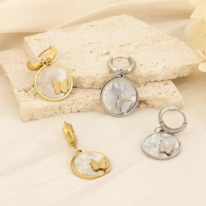 Detail of gold and silver butterfly earrings with mother-of-pearl inlay and frosted finish