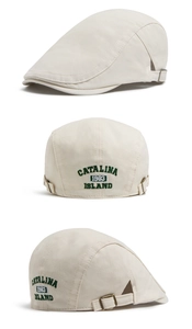 Detail of adjustable metal buckle and green vintage embroidery on beige flat cap