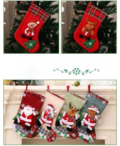 Detail of burlap Christmas stockings with 3D Santa and reindeer embroidery