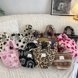 Detail of plush tote bags in leopard, heart, and cow patterns with soft faux fur texture