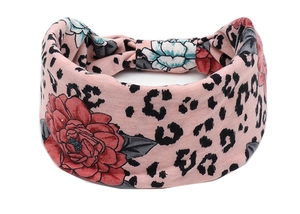 Détail d'un bandeau rose à motif léopard floral avec un nœud torsadé élégant et large