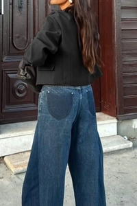 Back view of a casual black long-sleeve vest jacket paired with wide-leg blue jeans