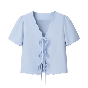 Light blue short sleeve top featuring scalloped edges and three front bow-tie closures