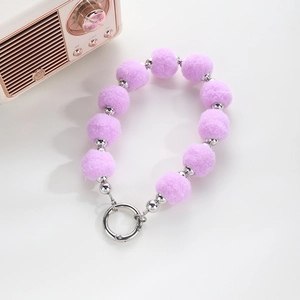Detail of purple pompom and silver bead keychain with a round spring clasp charm