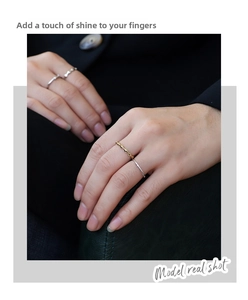 Detail of geometric gold ring with rhombic facets and a sleek silver band on a model hand