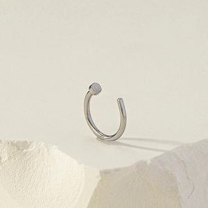 Anello al naso a C in argento minimalista senza piercing su trama di pietra bianca