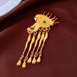 Vintage gold sunburst brooch with green eye and long wavy metal drop tassel charms