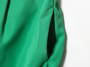 Detailed close-up of grass green fabric texture and stitching on side pocket