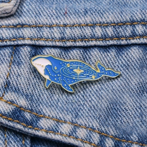 Blue cartoon whale enamel brooch with starry sky pattern on a blue denim jacket