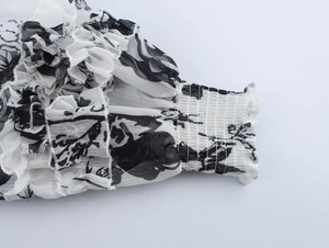 Detail of floral chiffon sleeve with layered ruffles and smocked elastic cuffs