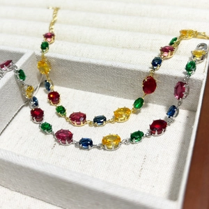 Detail of gold and silver bracelets featuring vibrant multi-colored crystal oval stones