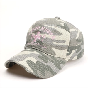 Détail de la broderie croix rose et de la visière usée sur casquette camouflage